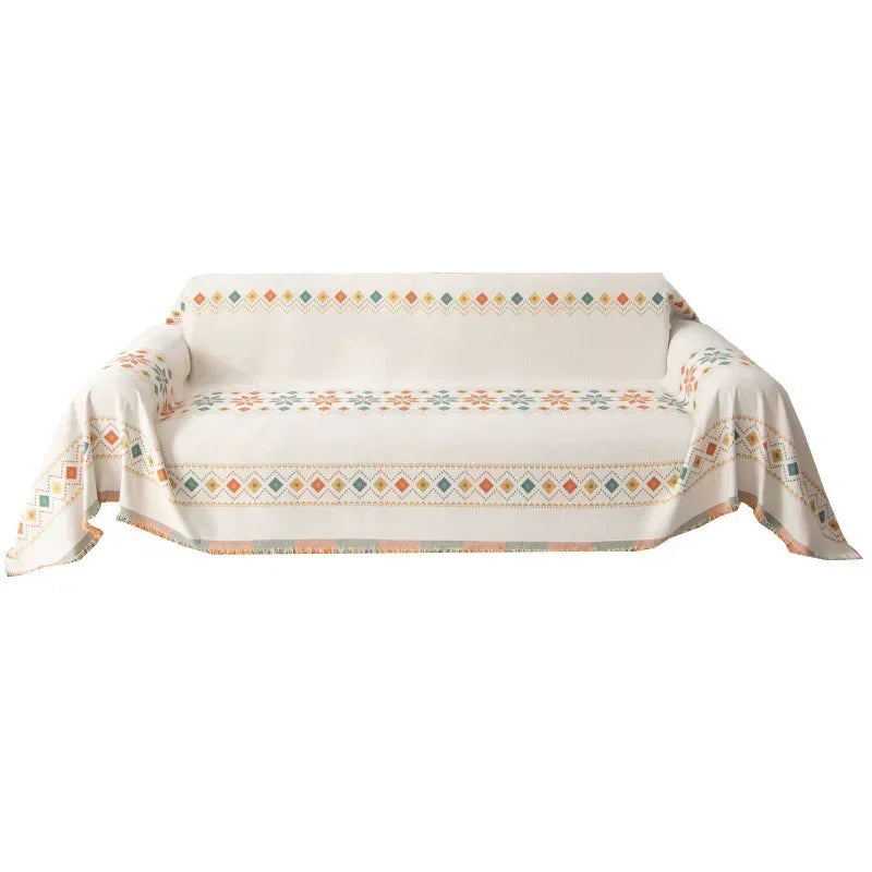 A beige bohemian jacquard sofa cover featuring geometric patterns in soft orange and teal tones.