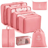 A set of pink travel packing cubes and storage organizer bags for clothing.