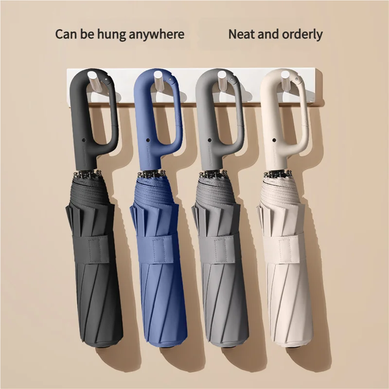 Three fully automatic windproof folding umbrellas in gray, blue, and white hanging on a wall.