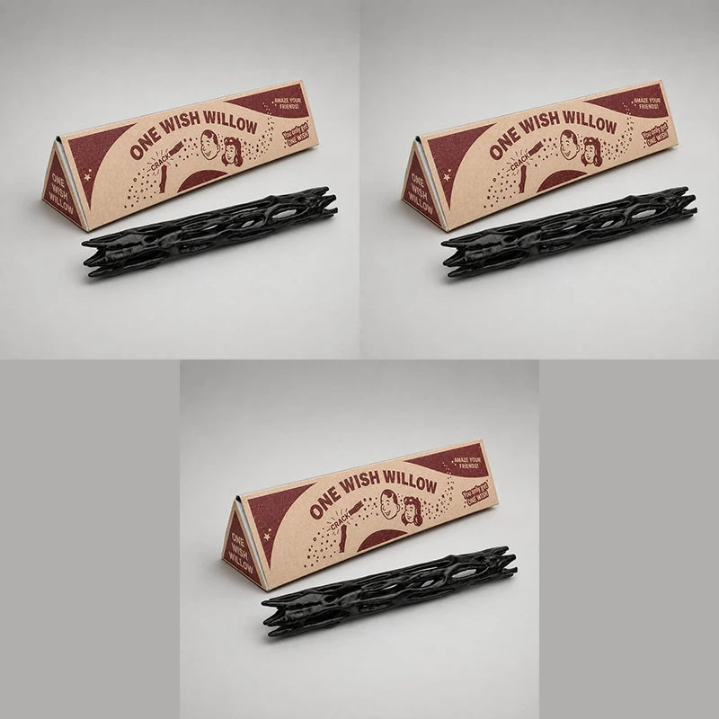A gift box containing a black willow wood wishing stick with a decorative label.
