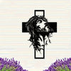 Silhouette de la tête et de la barbe de Jésus dans une croix sur un mur de brique blanche.
