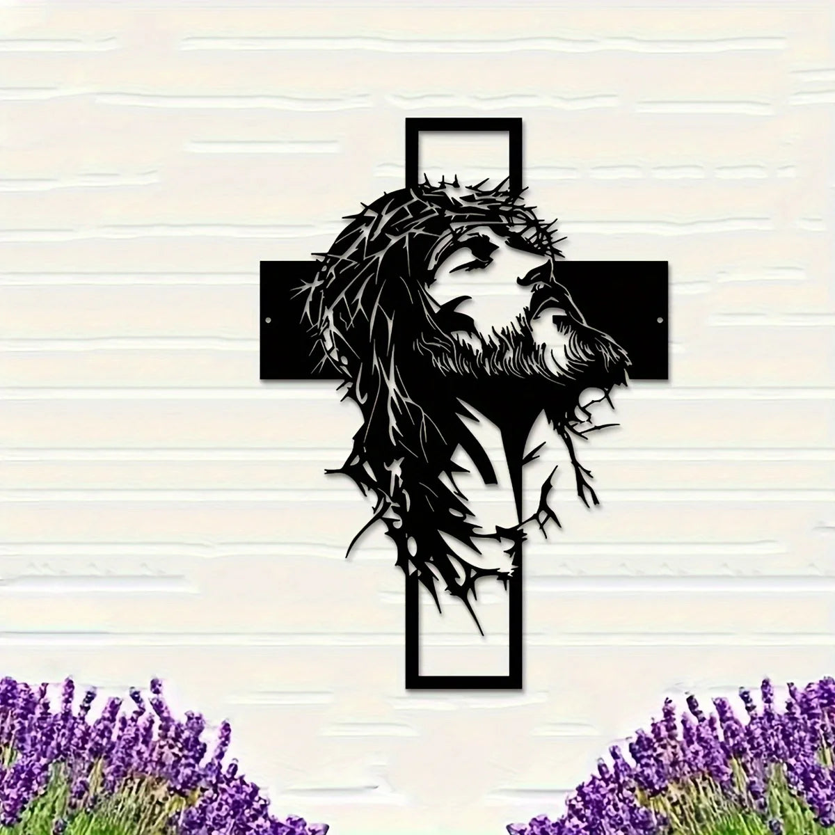 Silhouette de la tête et de la barbe de Jésus dans une croix sur un mur de brique blanche.