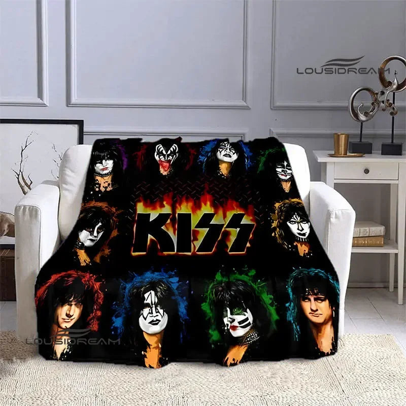 A black flannel throw blanket featuring various printed images of the Kiss band members.