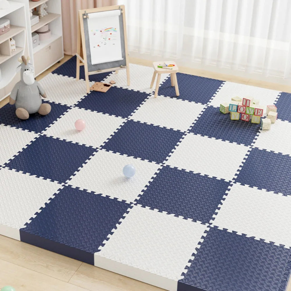 A blue and white interlocking foam play mat with a checkered pattern, featuring a wooden easel and toys.