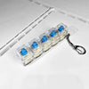 A clear plastic keychain fidget toy featuring blue LED mechanical keycaps attached to a metal ring.