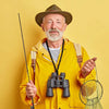 An older man wearing a wide-brimmed hat and a yellow jacket holds a fishing rod and a paracord lanyard keychain.