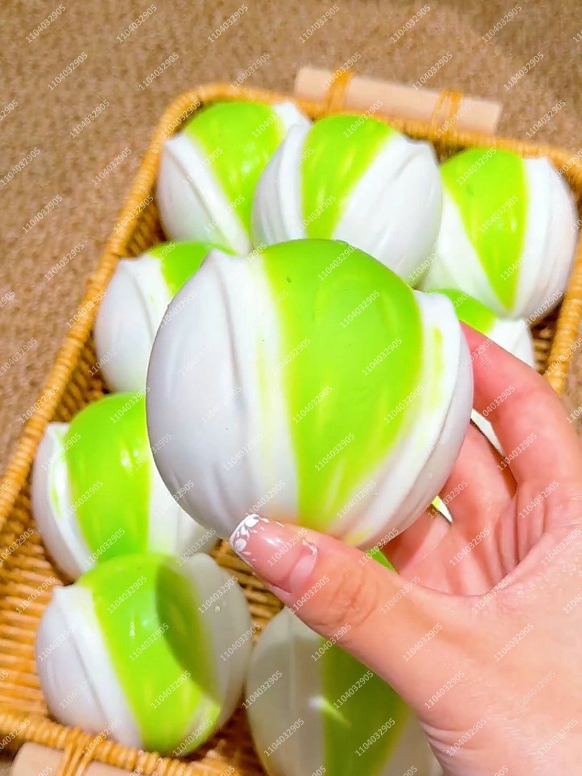 Eine Hand hält einen knisternden Kartoffel-Stressball in leuchtendem Limettengrün und Weiß in einem geflochtenen Korb.