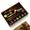 A vintage calligraphy fountain pen set with wax seal stamp kit displayed in a wooden box.