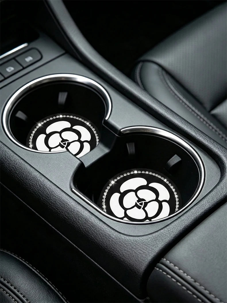 Close-up of car cup holders featuring non-slip coasters with a white camellia paw pattern.