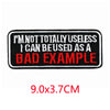Black embroidered iron-on letter patch with red text that reads I'M NOT TOTALLY USELESS I CAN BE USED AS A BAD EXAMPLE