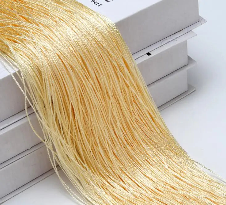 A bundle of golden beaded thread used for a curtain or room divider is displayed next to its packaging box.