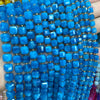 A close-up of a strand of bright blue natural stone square faceted beads for jewelry making