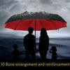 Silhouette of a family under a red umbrella against a dark, stormy sky.
