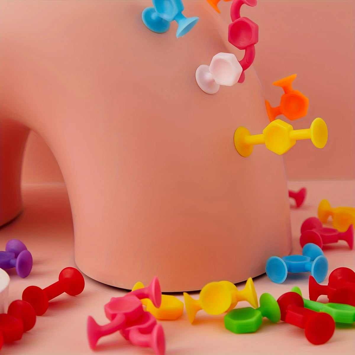 A collection of colorful silicone suction bath toys, including various shapes and colors like blue, pink, yellow, and orange,