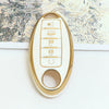 A close-up of a white and gold 5-button soft TPU car key fob cover for a Nissan vehicle.
