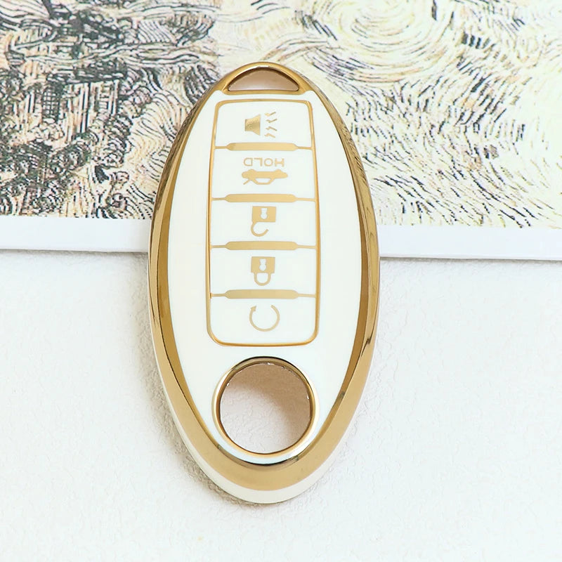 A close-up of a white and gold 5-button soft TPU car key fob cover for a Nissan vehicle.