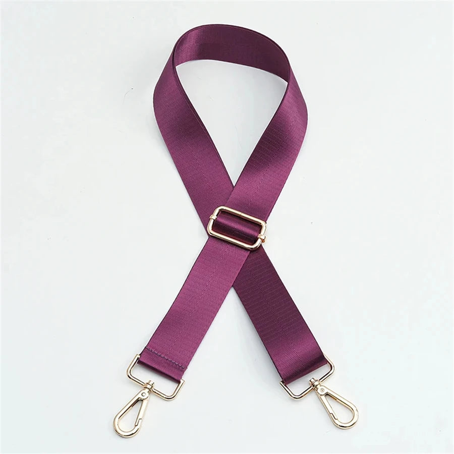 A purple nylon bag strap with a gold buckle shown diagonally.