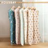 A display of light pink and green breathable cotton baby sleep sacks hanging on a wooden rod.