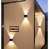 A wall light fixture illuminates a white wall with a dramatic upward and downward glow.