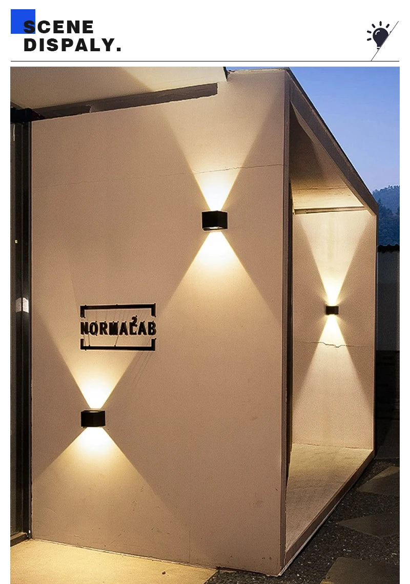 A wall light fixture illuminates a white wall with a dramatic upward and downward glow.