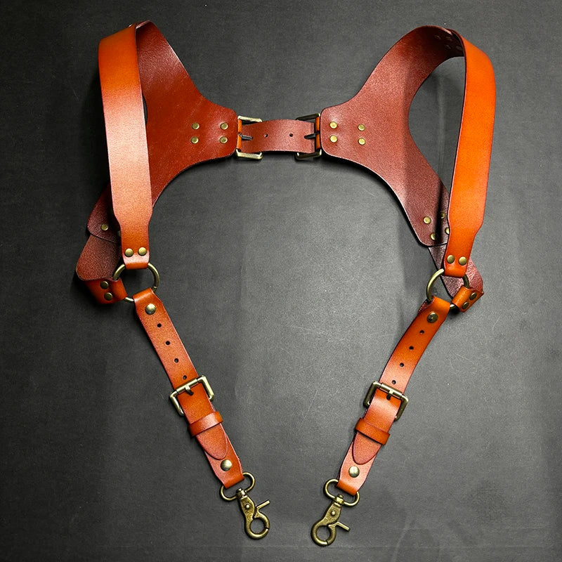 A pair of genuine brown leather double shoulder suspenders with brass hardware.