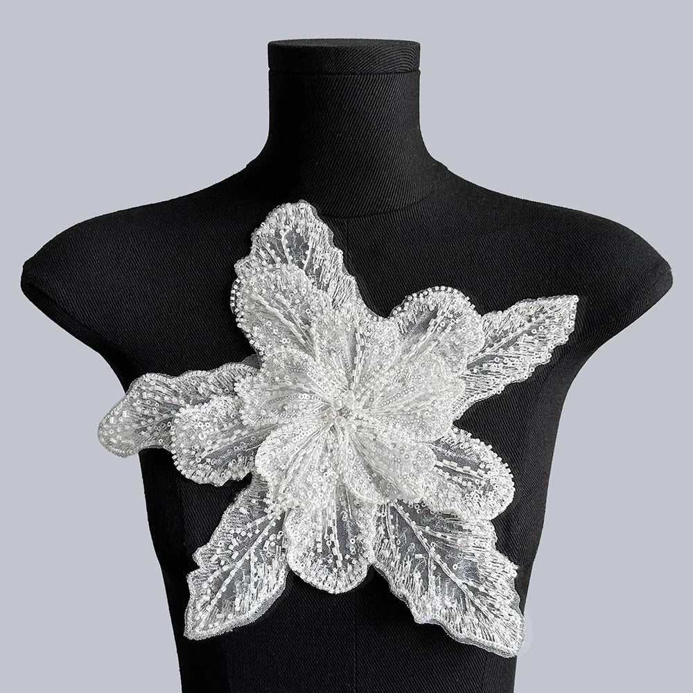 Silver floral lace applique patch with intricate sequins displayed on a black mannequin
