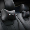 Black PU leather car headrest pillows and seatbelt shoulder pads installed in a vehicle seat.