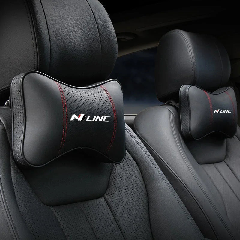 Black PU leather car headrest pillows and seatbelt shoulder pads installed in a vehicle seat.