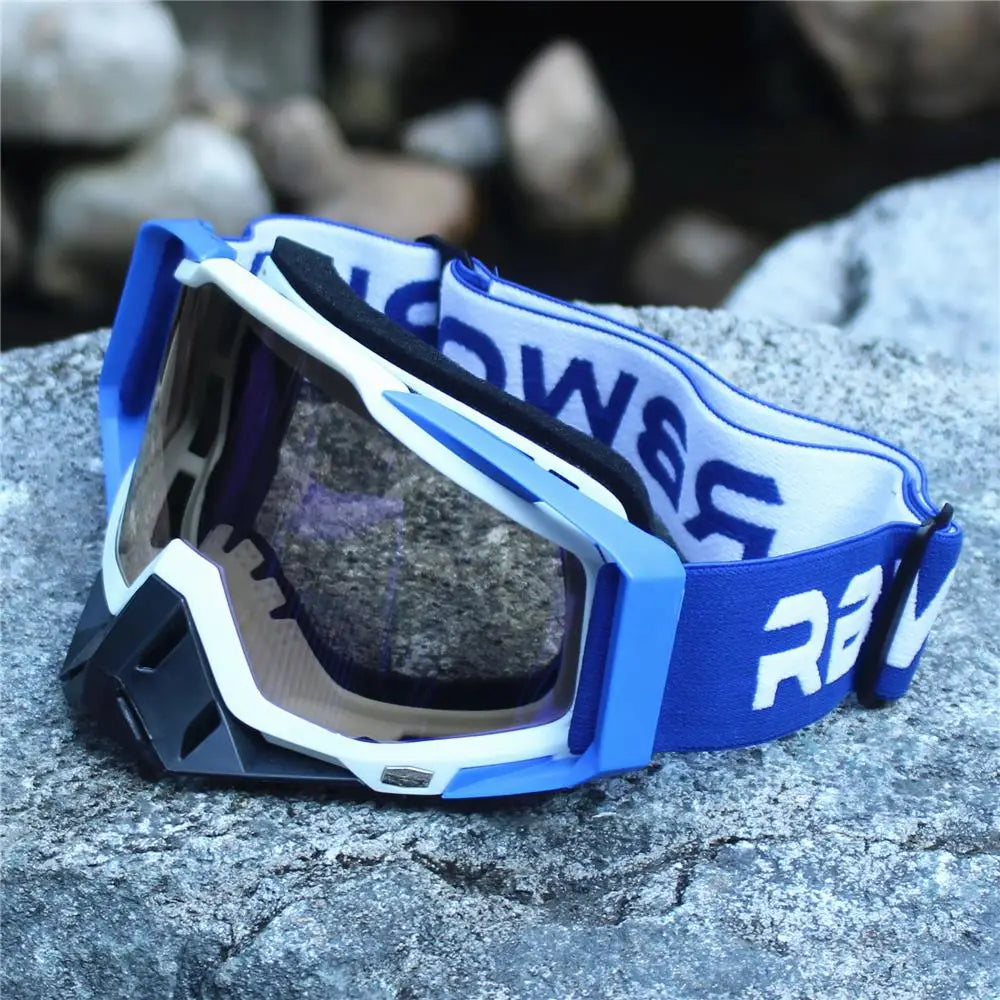 Blue and white retro motorcycle sunglasses resting on a gray rock surface.