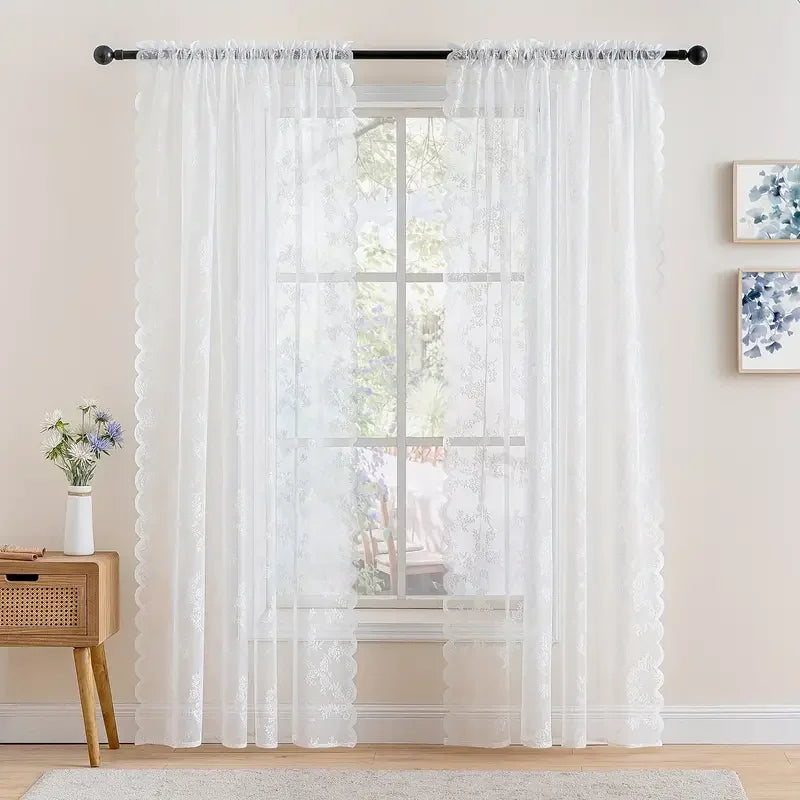 White vintage floral lace curtain panel filtering light through a window.