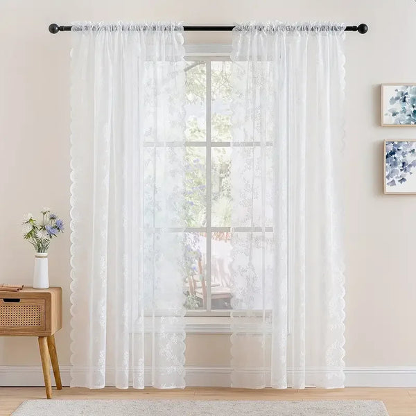 White vintage floral lace curtain panel filtering light through a window.