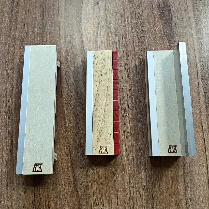 A set of wooden fingerboard ramps featuring a quarter pipe and rail, displayed on a wooden surface.
