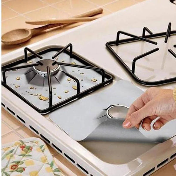 Une main pose un protecteur de brûleur en silicone réutilisable sur une grille de cuisinière.