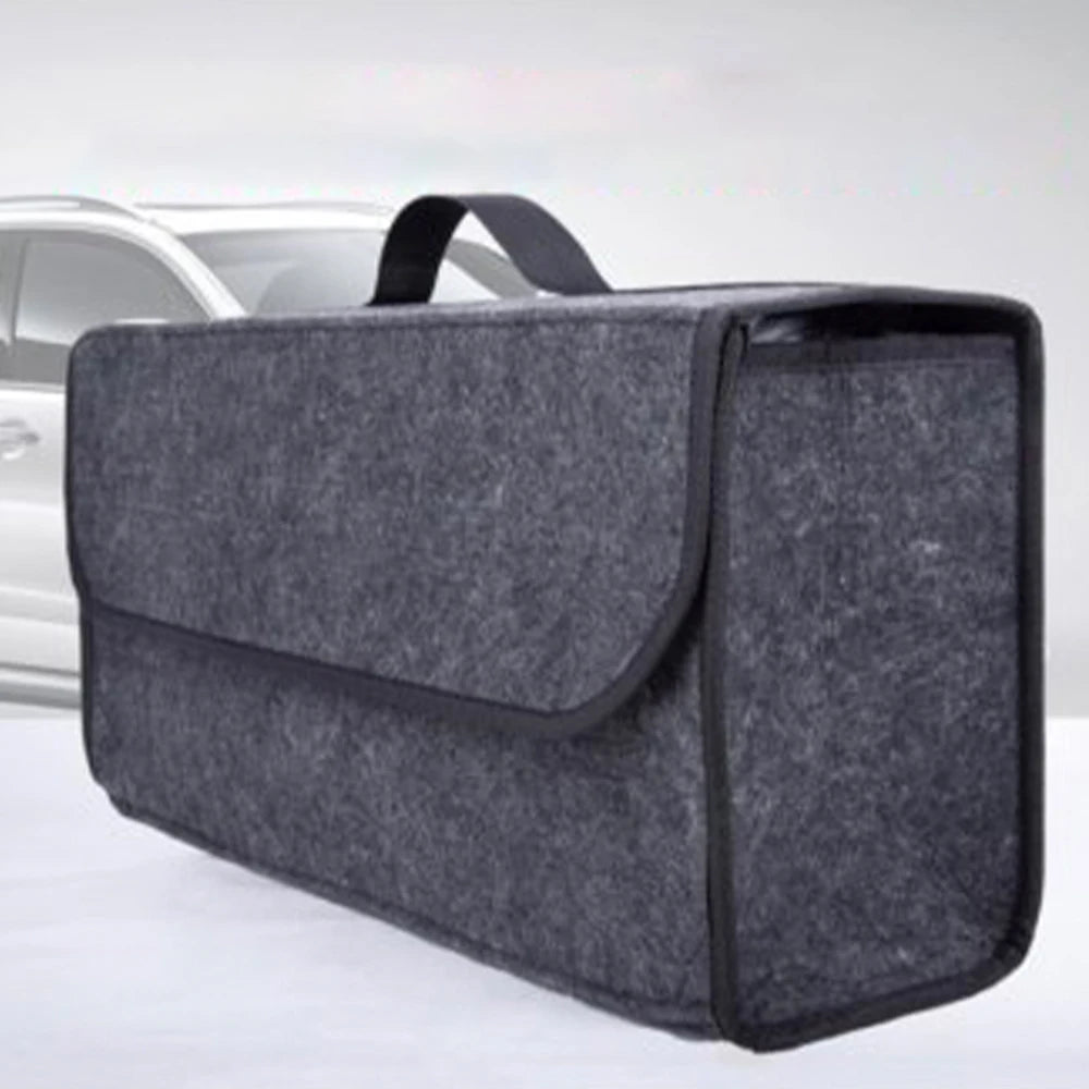 A dark gray foldable boot and trunk organizer bag resting on a light surface.