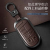 A dark brown leather and metal key case with a lanyard attached, featuring various key cutouts.