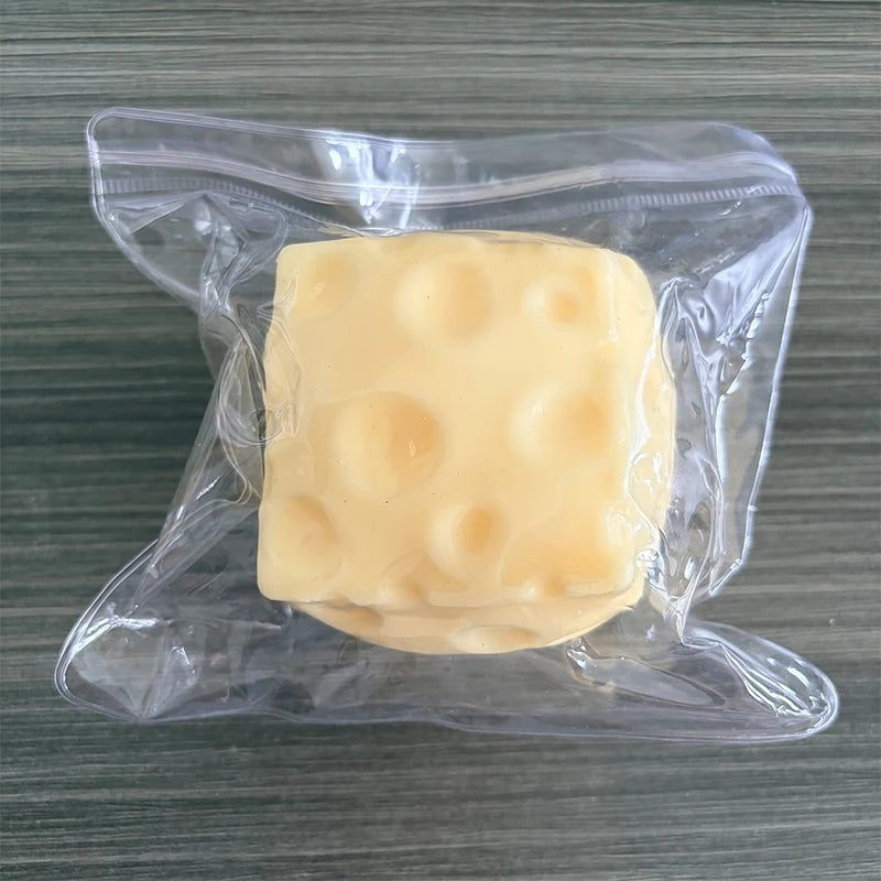 Ein quadratisches, blassgelbes Silikon-Fidget-Würfel in einer klaren Plastiktüte.
