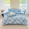 A light blue fluffy fleece duvet cover with a white rabbit design displayed on a bed in a bright room.