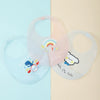 A translucent silicone baby bib featuring a rainbow and cute animal print on a light pink background.