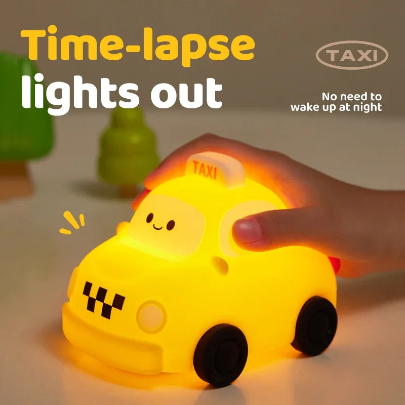 A hand is illuminating a yellow car-shaped time-lapse light out night light on a white surface.