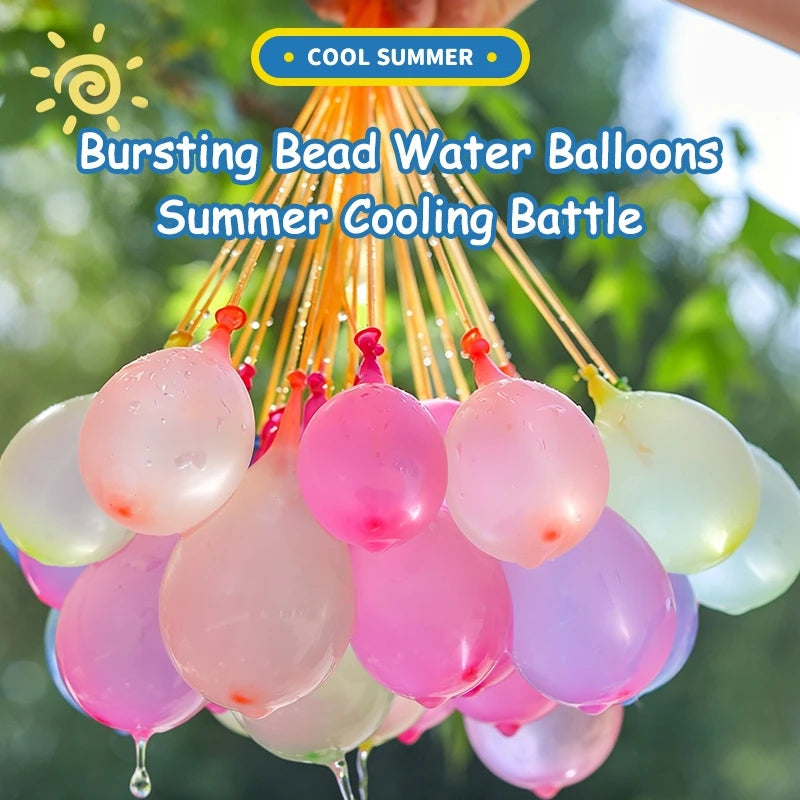 A bunch of bursting bead water balloons in various pink and yellow colors are suspended against a green, leafy background.