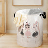 A large white storage basket with a unicorn ballerina print, featuring light yellow and gray fabric draped over the rim.