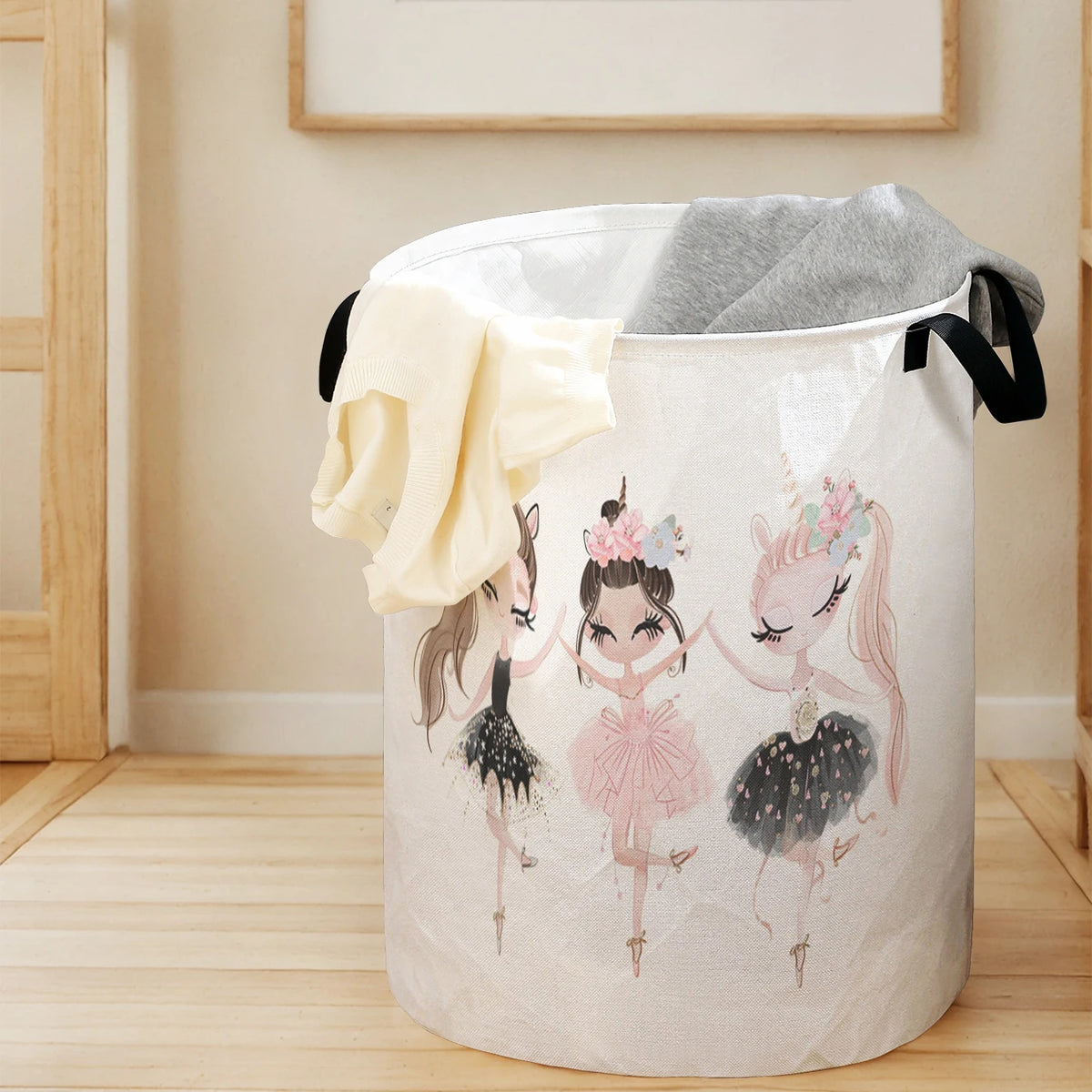 A large white storage basket with a unicorn ballerina print, featuring light yellow and gray fabric draped over the rim.