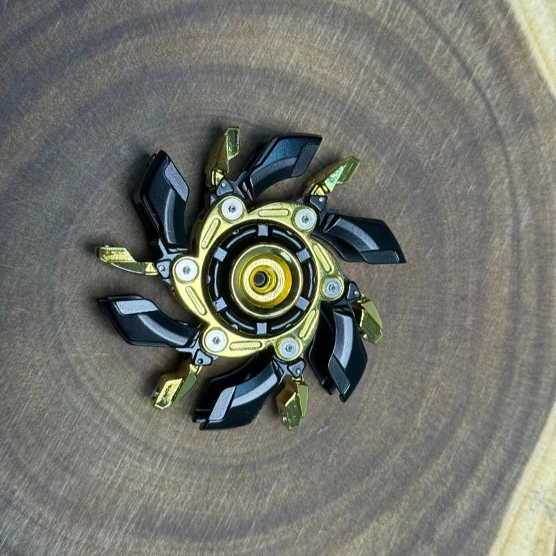 A precision metal fidget spinner with black and gold accents resting on a wooden surface.