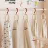Wall-mounted organizer hooks displaying folded beige and white scarves on a white rack.