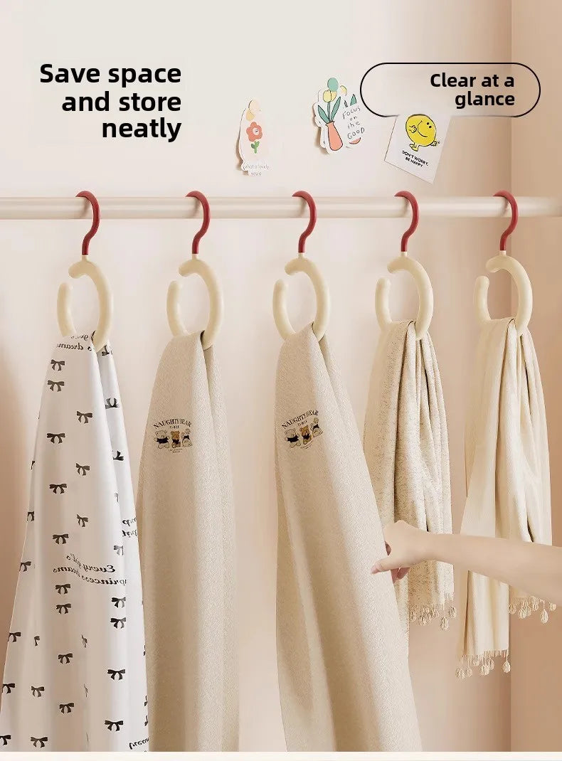 Wall-mounted organizer hooks displaying folded beige and white scarves on a white rack.