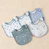 A collection of light blue and gray cotton baby bibs with various patterns and shapes laid out on a beige background.