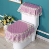 A white toilet seat covered with a purple quilted fabric and lace trim, featuring a pink ruffled skirt.