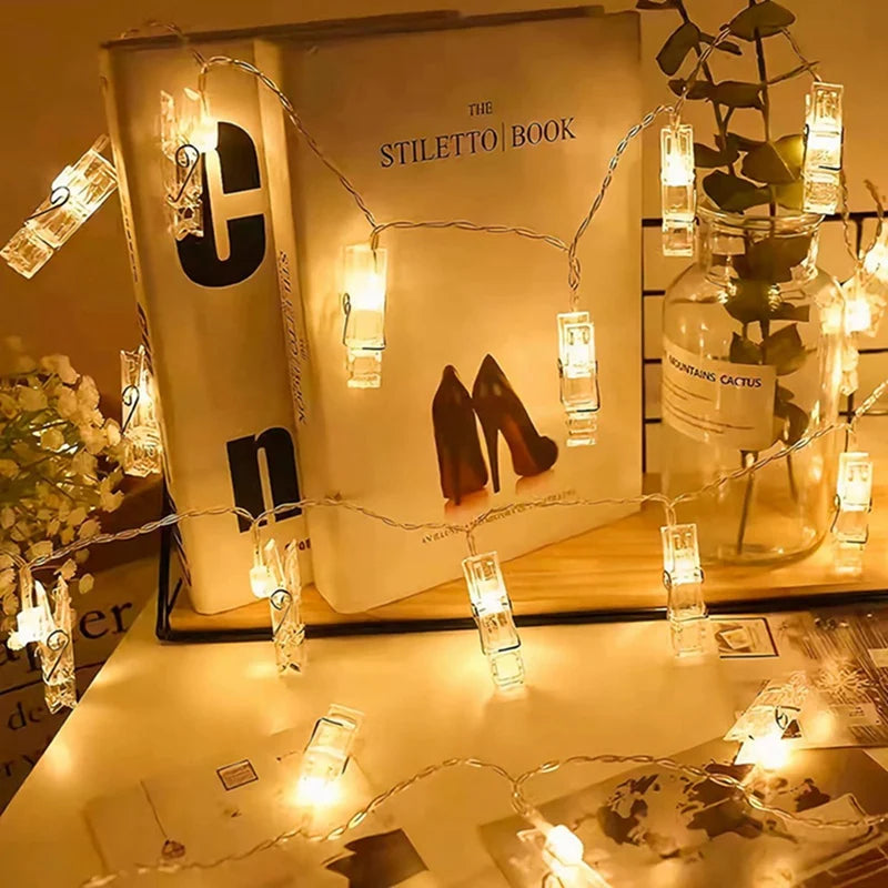 A book titled The Stiletto Book is illuminated by warm white LED photo clip string lights.