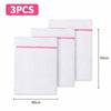 Three white mesh laundry bags with pink trim are displayed side by side.