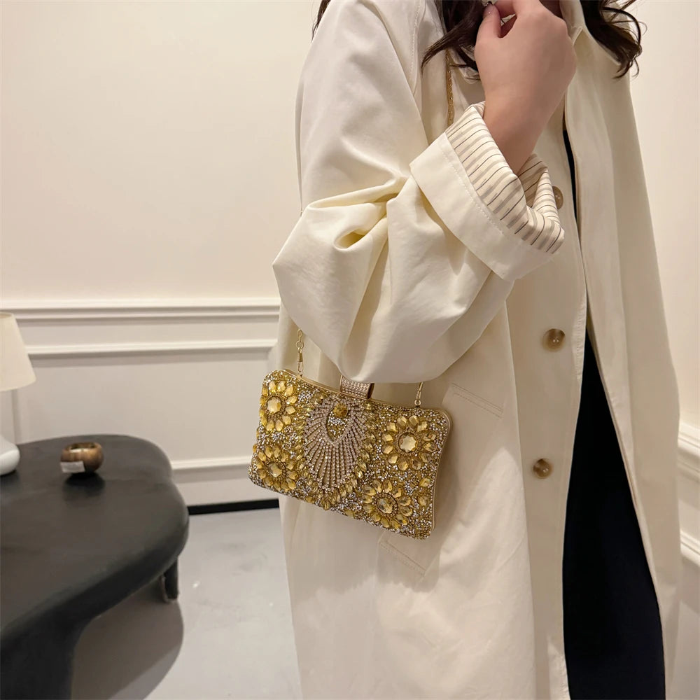 A woman wearing a cream-colored coat is holding a gold rhinestone evening clutch.